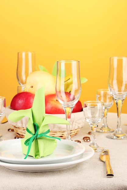 Table setting in green and yellow tones on color background