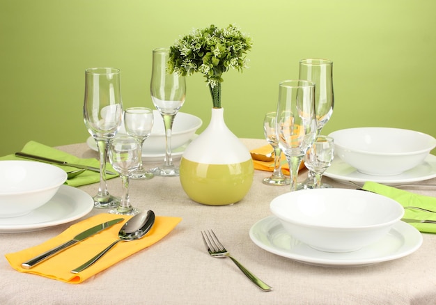 Table setting in green and yellow tones on color background