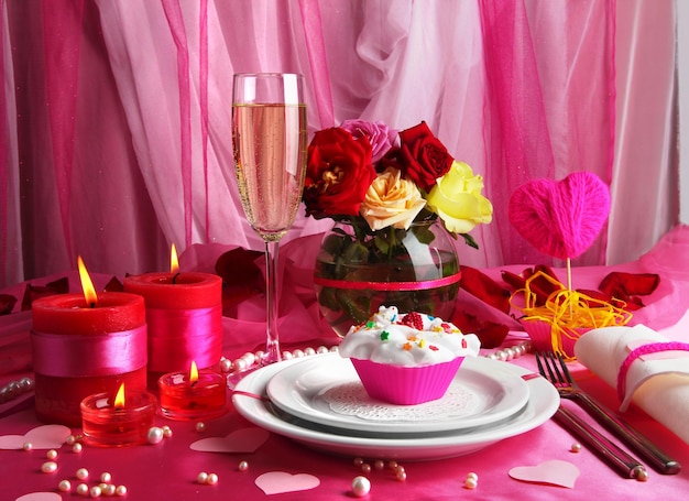 Table setting in honor of Valentine's Day on white fabric background