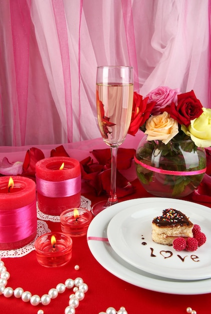 Table setting in honor of Valentine's Day on white fabric background