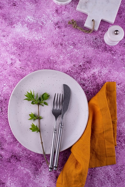 Table setting on lilac concrete background