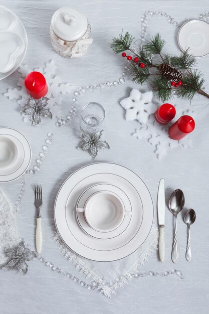 Table setting for New Year and Christmas for one person with a white tablecloth and a soup plate