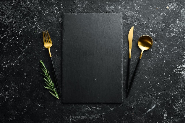 Photo table setting slate black stone plate with cutlery top view free copy space