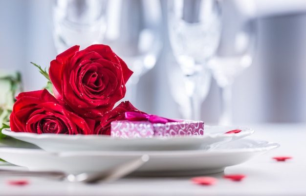 Regolazione della tavola per san valentino o il giorno del matrimonio con rose rosse regolazione romantica della tavola per due