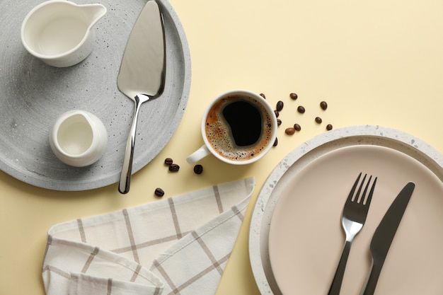 Table setting with cup of coffee on beige, top view