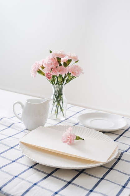 흰색 배경에 접시, 칼 붙이, 꽃이 있는 테이블 설정