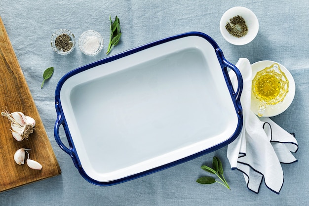 Table setting with empty ceramic baking dish on a blue linen tablecloth