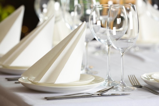 Table setting with empty glasses plates and cutlery indoors