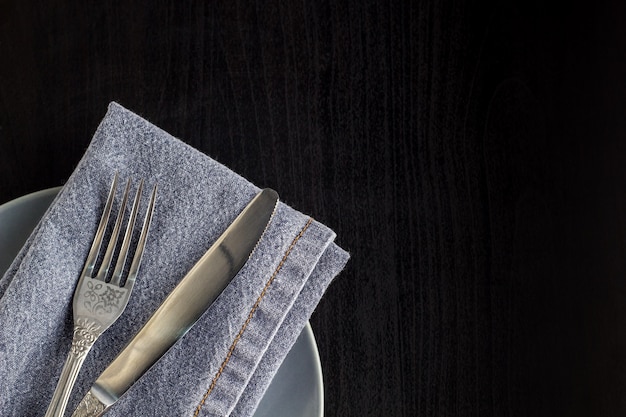 Table setting with empty plate napkin fork and knife