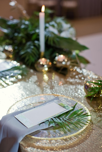 Table setting with mockup menu card and green exotic palm leaf Green tropical dinner concept