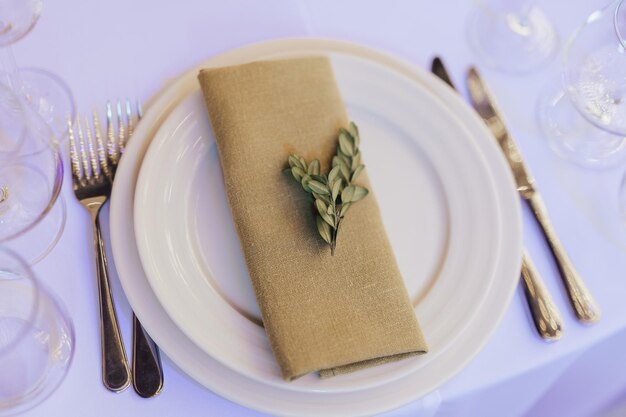 A table setting with a napkin and a leaf on it