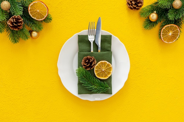 Table setting with spruce, plate, flatware isolated background top view