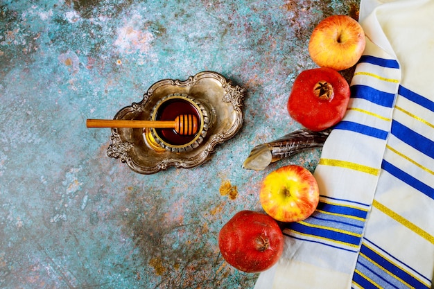 Foto sul tavolo della sinagoga ci sono i simboli della mela e del melograno di rosh hashanah, shofar talith