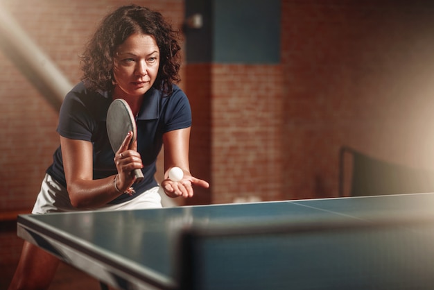 Foto ping-pong, giocatrice con la racchetta colpisce la palla