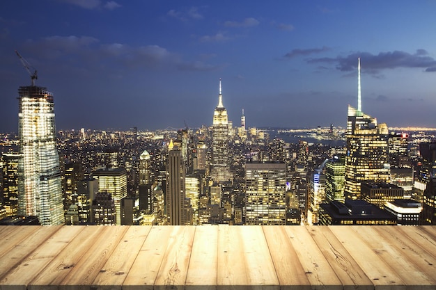 Table top made of wooden dies with New York city view at dusk on background template