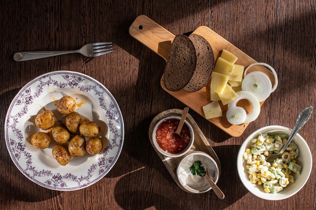 Table top view of baked cherry potatoes and salad