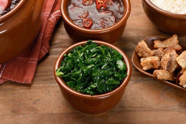 a table with bowls of food including kale kale and rice