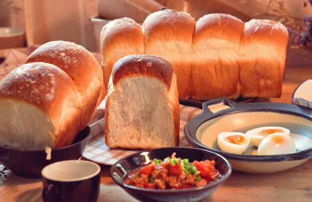 A table with bread and a bowl of eggs