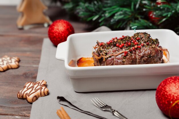 Foto tavola con piatti di natale carne di manzo al forno o arrosto con spezie carne tenera mezzaluna per la cena di natale in famiglia