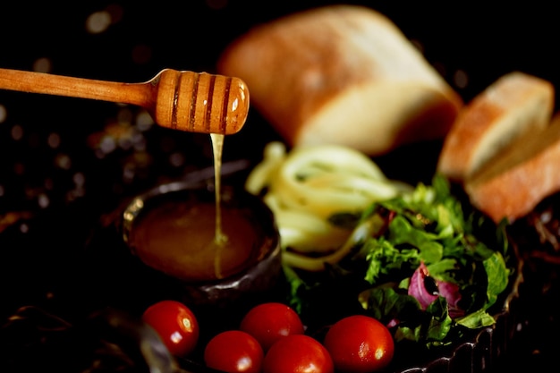 Стол с вкусной и питательной едой Медовый сыр и помидоры Мед стекает с деревянной Здоровой пищей