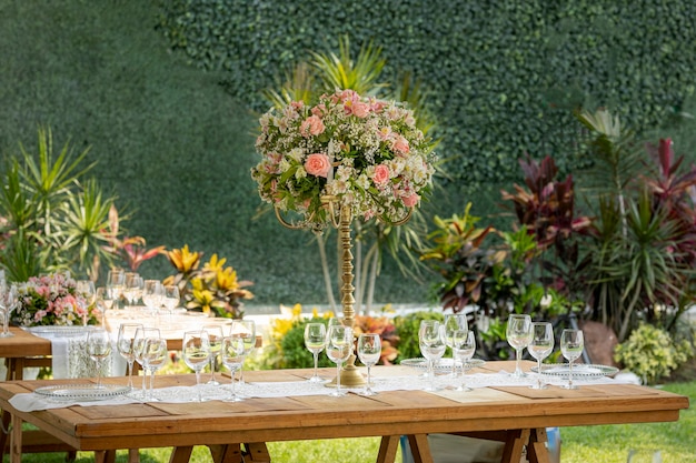 Table with flower arrangement and crockery at a social event in Event Garden