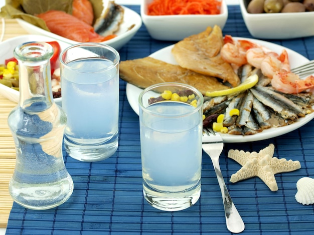 A table with food and a plate with fish and a glass of water