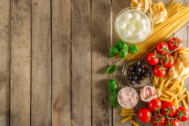 Table with ingredients to prepare italian pasta