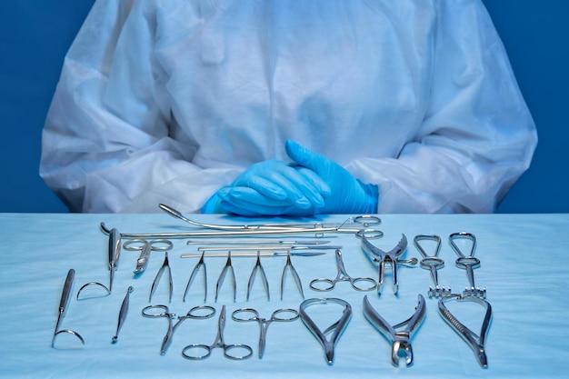 手術やドレッシング用の器具と医療従事者の手が置かれたテーブル