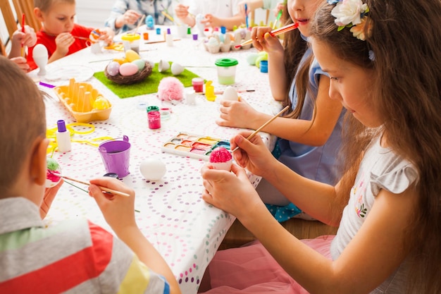 The table with paints and Easter eggs. Friends preparing for Easter.