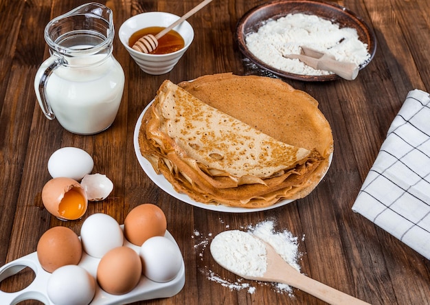 Photo a table with pancakes, milk, and flour on it