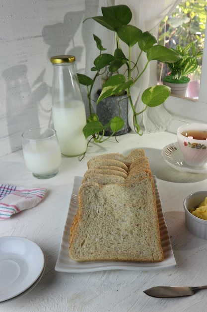 A table with a plate of bread and milk