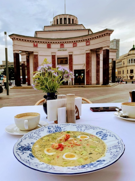 A table with a plate of food and a building in the background