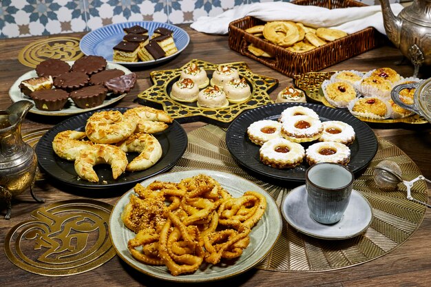 a table with plates of food including donuts cookies and a cup of coffee