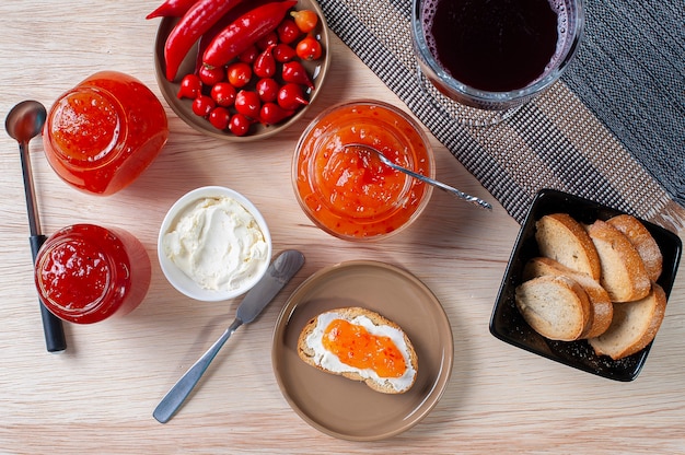 Table with toast accompanied by curds and pepper jams. Glass of grape juice