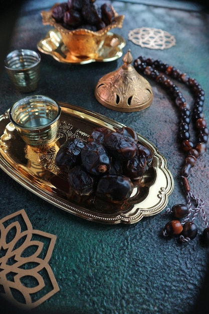 A table with a tray of dates and a glass of water.