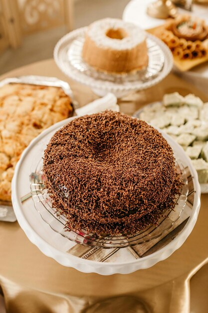 Photo a table with a tray of pastries and a plate of donuts with a cake on it