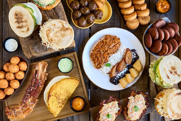 Table with typical Venezuelan food Creole pavilion arepas fried pork and stuffed empanadas