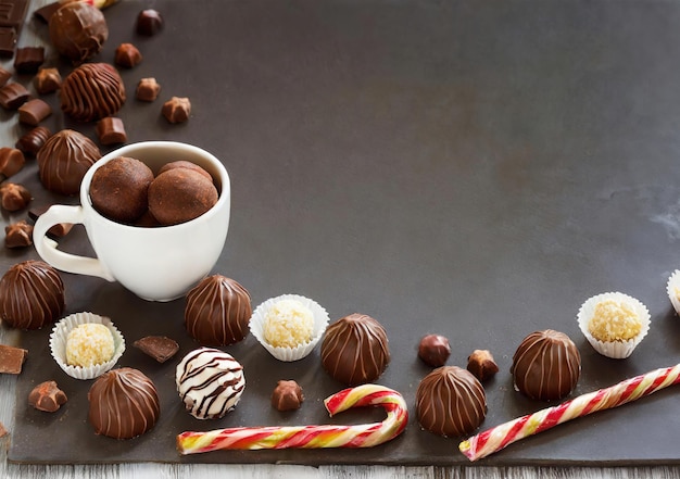 A table with a white cup and a variety of chocolate candies Concept of indulgence and enjoyment