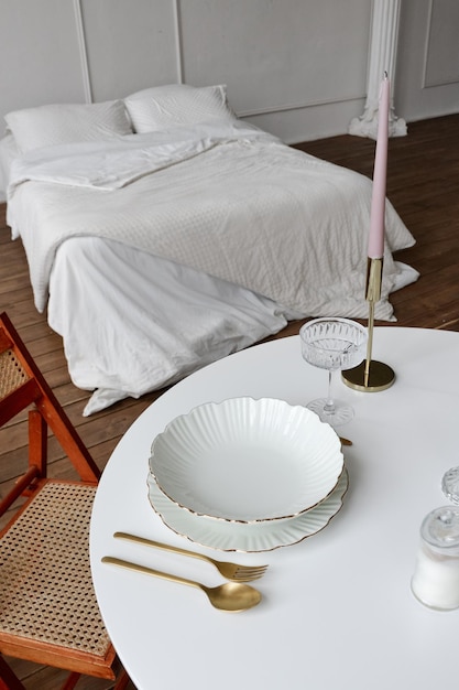 Photo a table with a white plate and gold cutlery on it.