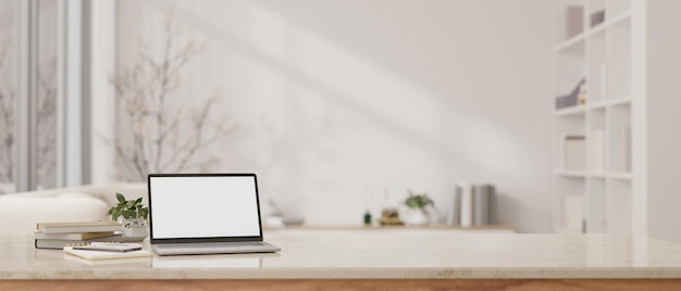 A table with a whitescreen laptop mockup over a blurred white living room in the background