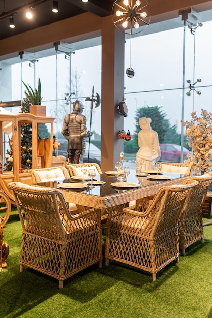 A table with wicker chairs and a statue of a knight on the left.