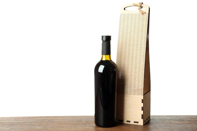 Table with wine bottle and gift box on white background