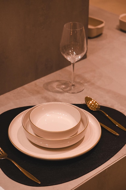 a table with a wine glass and a set of dishes with a spoon and a wine glass