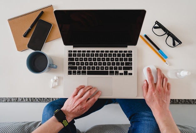 table workplace close-up man hands at home working typing on laptop