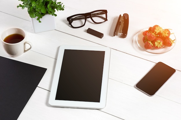 Tablet blank sheet glasses and coffee cup on office wooden table