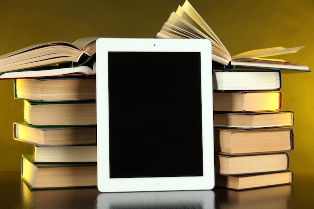 Tablet and books on bright background