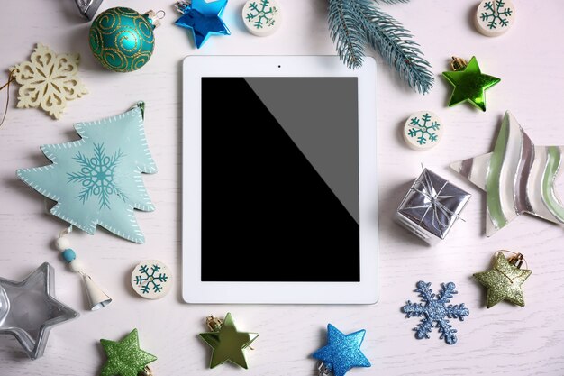 白い表面の木の表面のタブレットとクリスマスの装飾