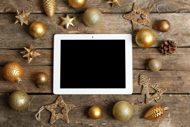 木製の背景にタブレットとクリスマスの装飾