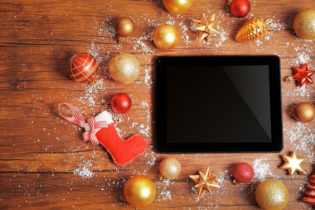 Tablet and Christmas decor on wooden table