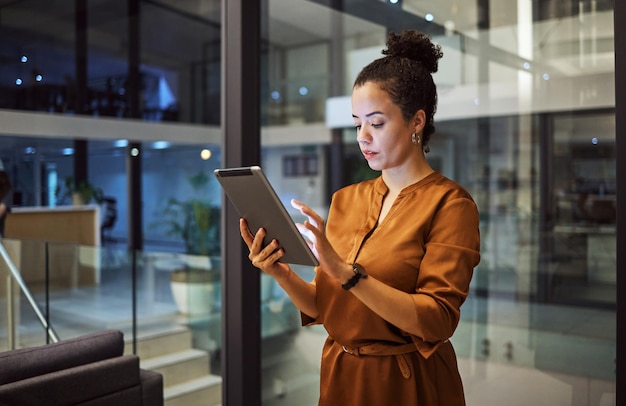 Tablet die 's nachts werkt en vrouwelijke werknemer die digitale strategie plant of typt in een kantoor Zakelijke technologie en online werknemer die technologie gebruikt om internet- en webonderzoek te doen voor een opstartproject